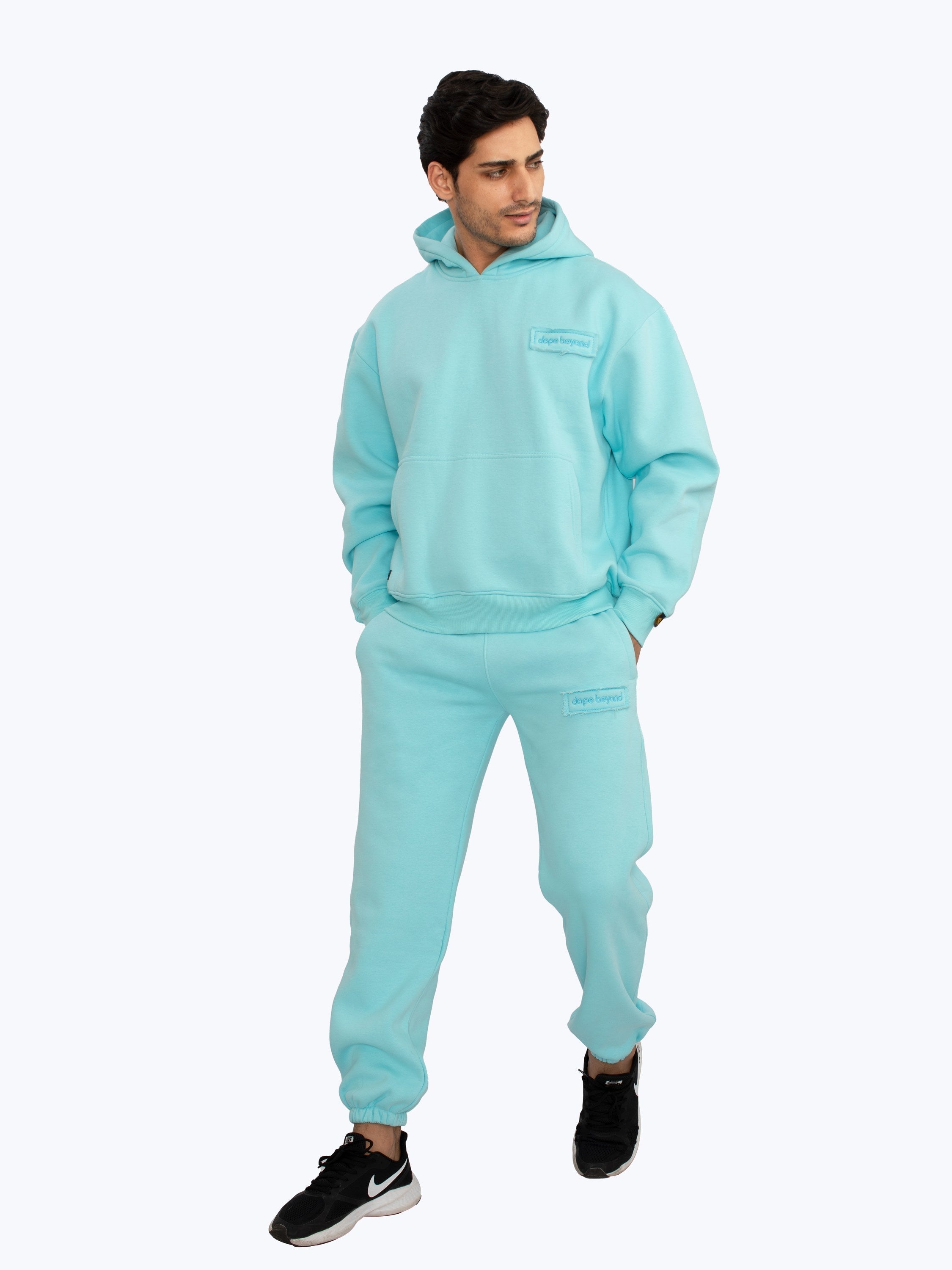 Model in aqua blue heavyweight joggers and matching hoodie by Dope Beyond