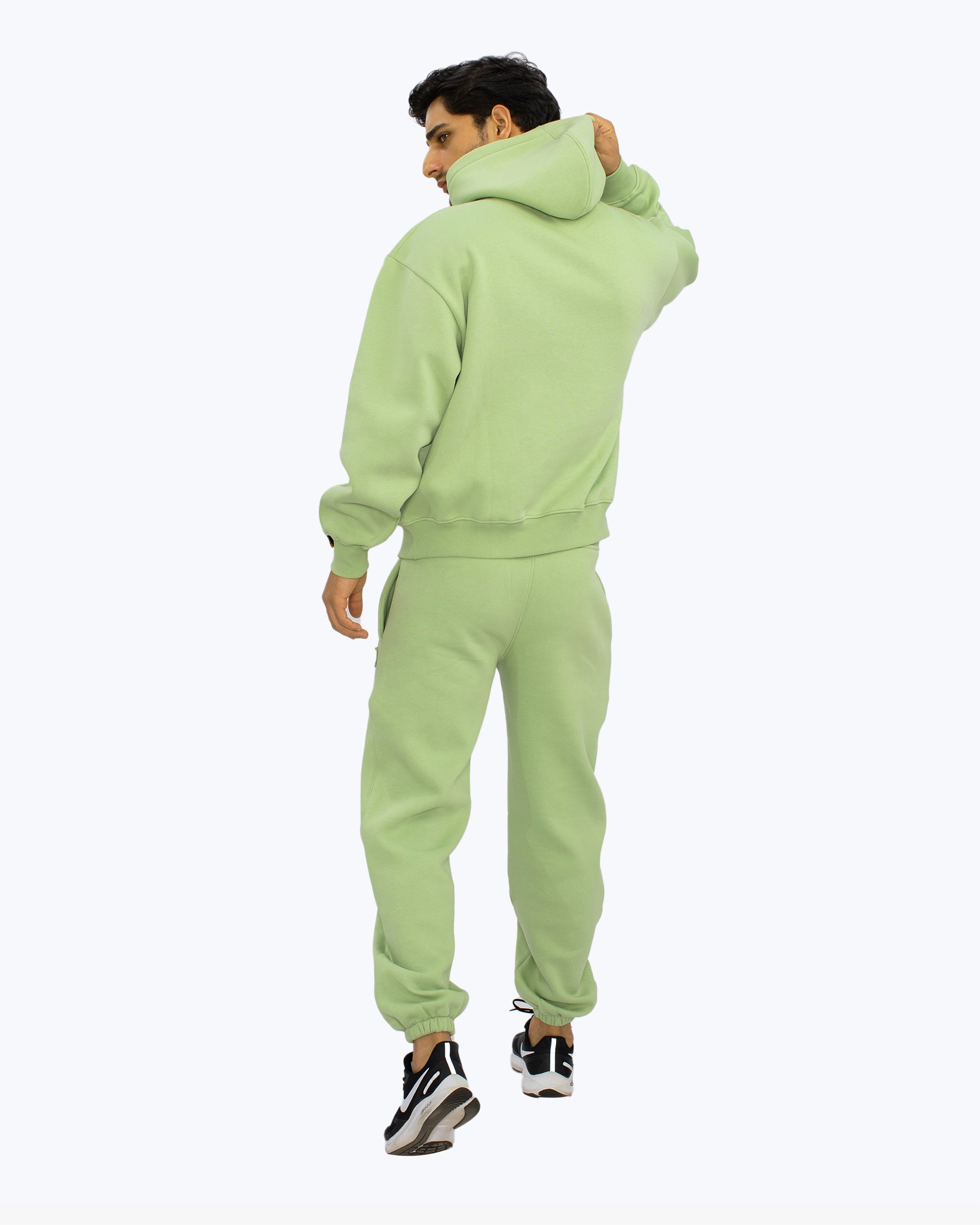Man wearing light green streetwear hoodie and joggers set from dopebeyond, back view