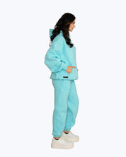 Woman in blue streetwear hoodie and joggers, side profile, DOPE BEYOND high-frequency apparel