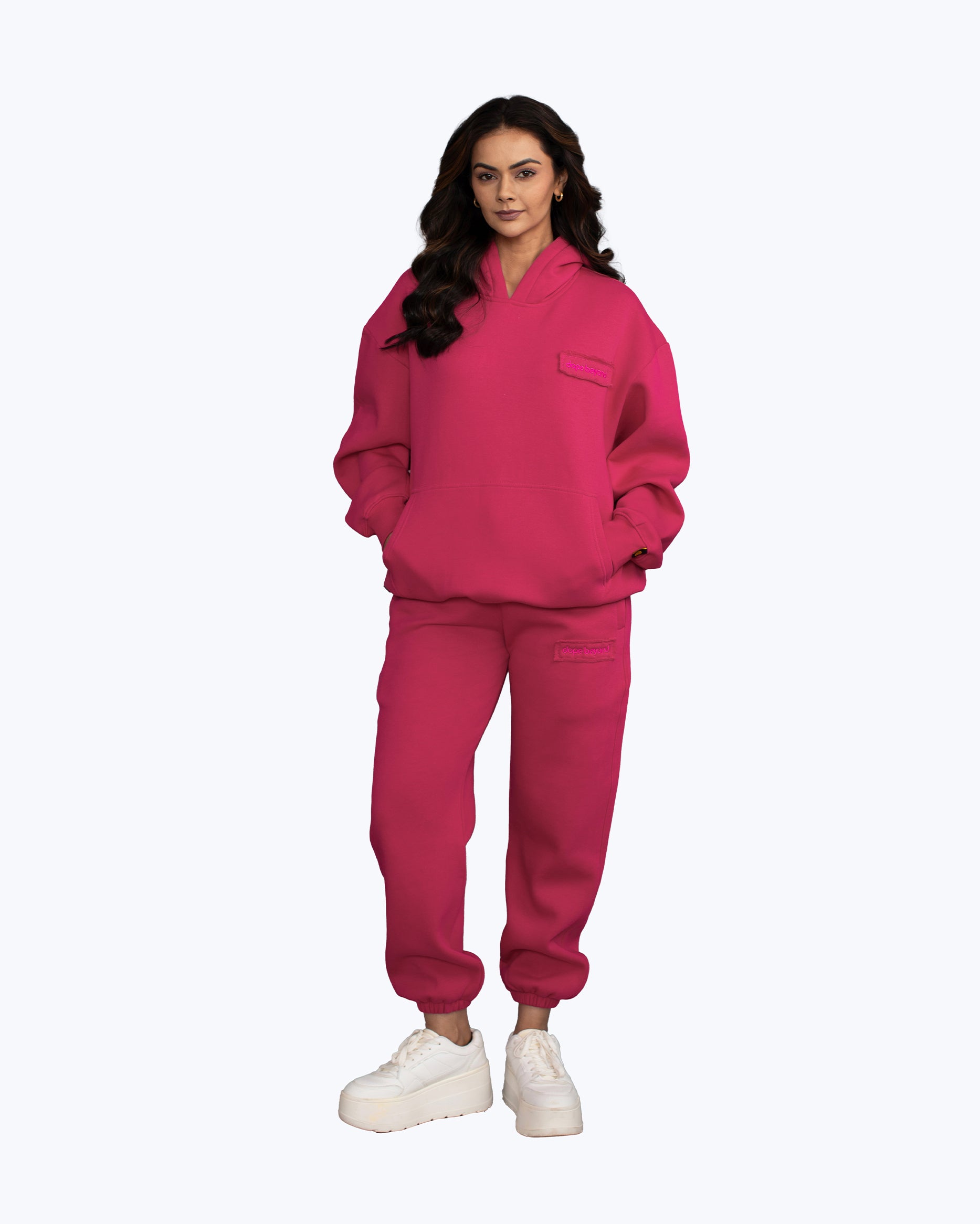 Woman in vibrant pink streetwear hoodie and joggers set from dopebeyond, white sneakers