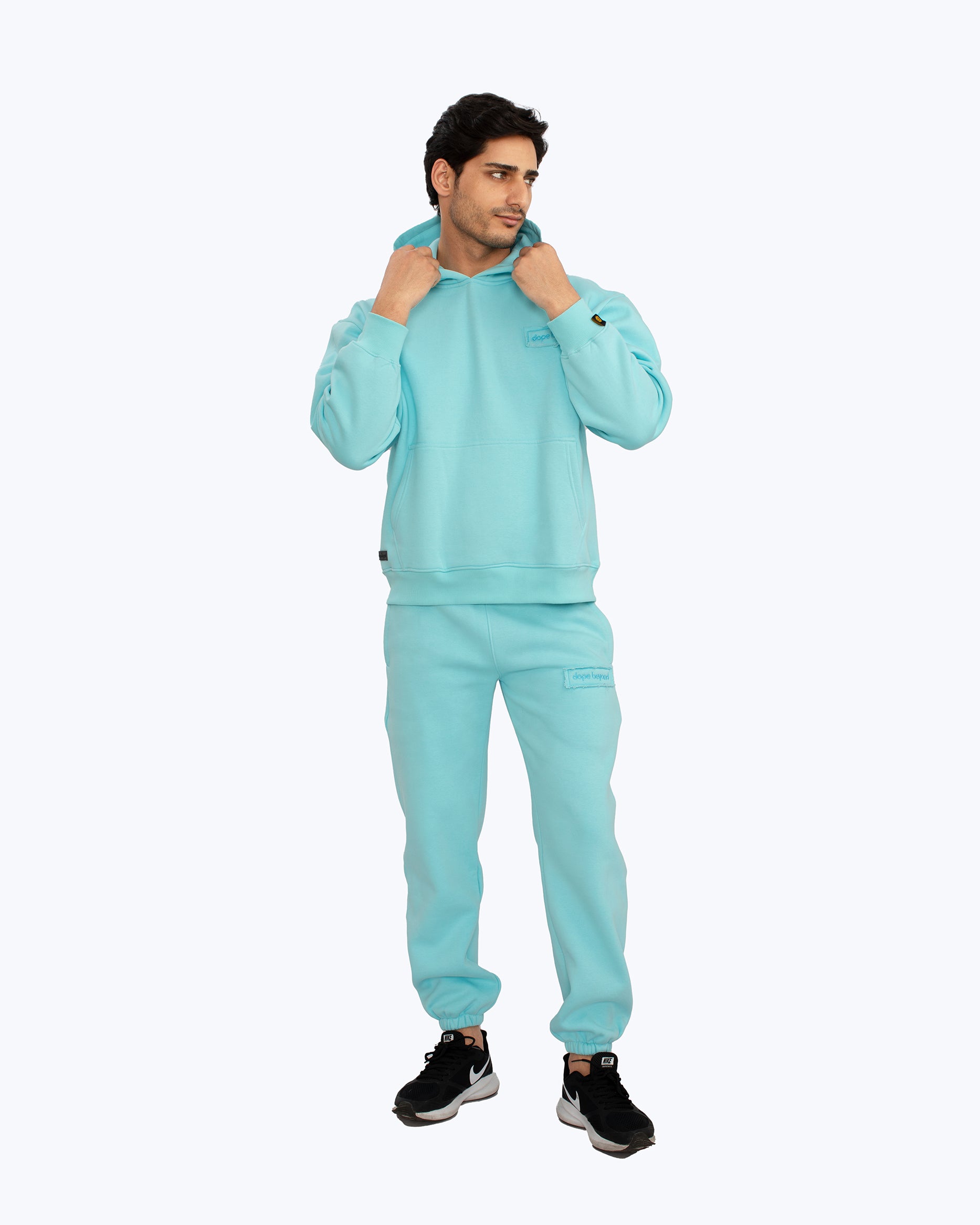 Man wearing light blue dopebeyond streetwear hoodie and joggers, sporty urban style
