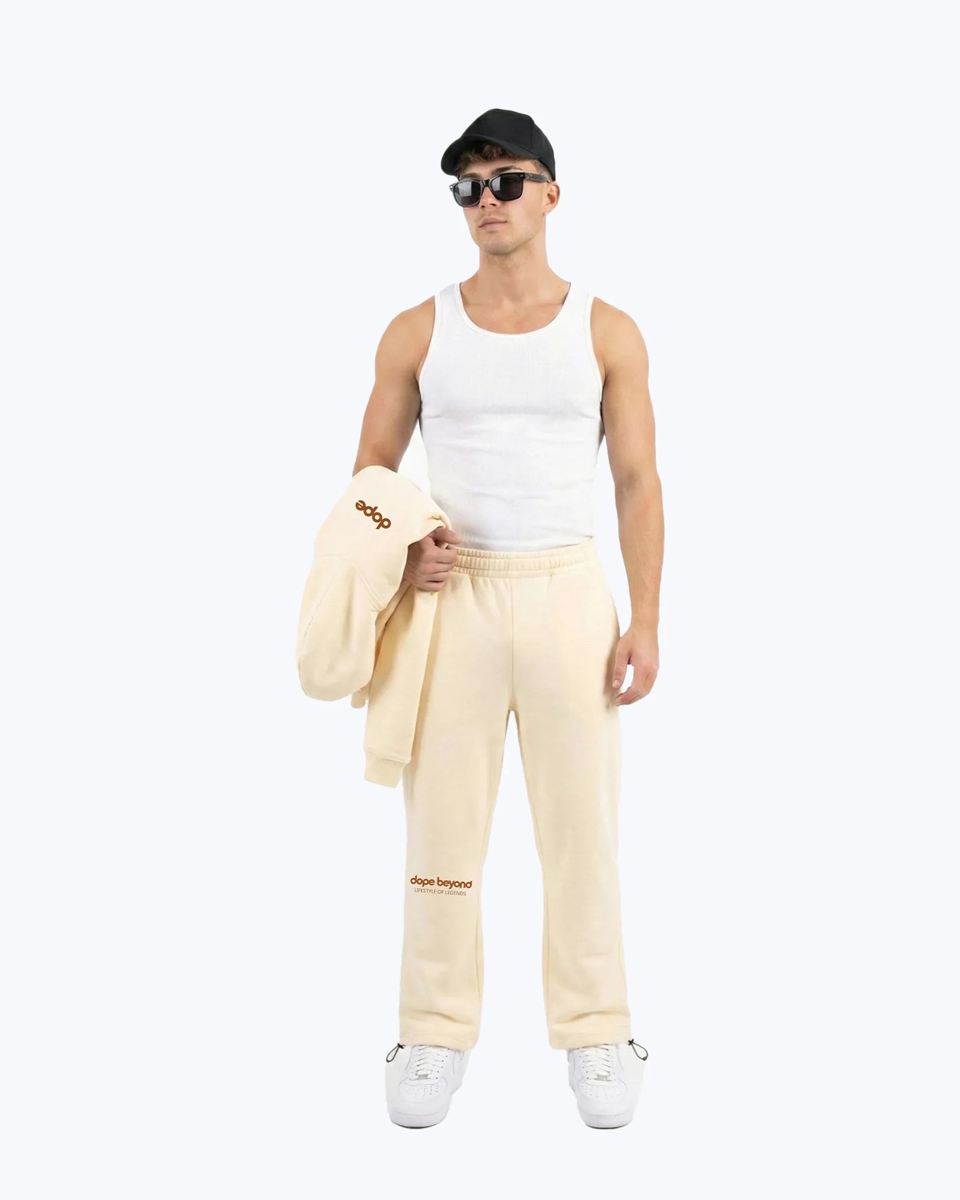 Male model in beige Dope Beyond heavyweight gym joggers and tank, streetwear style