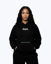 Woman wearing Dope Beyond black heavyweight hoodie with 'dope' and 'lifestyle of legends' text