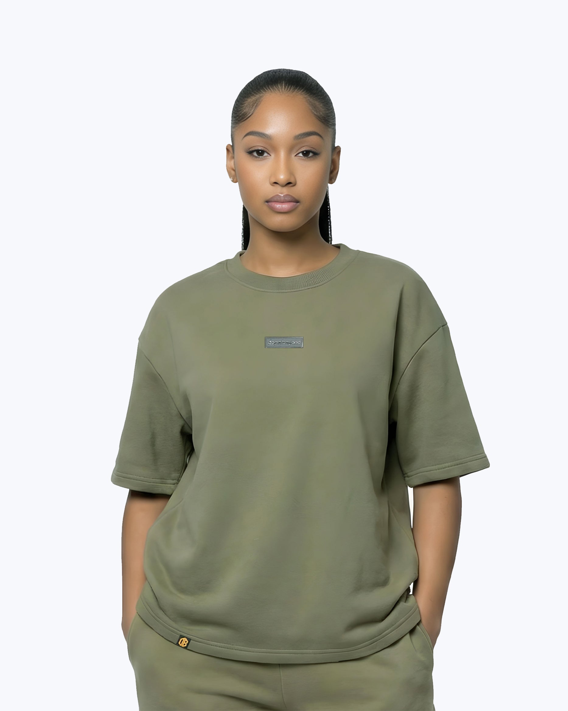 Woman wearing Dope Beyond olive green premium streetwear t-shirt, front view, minimal background