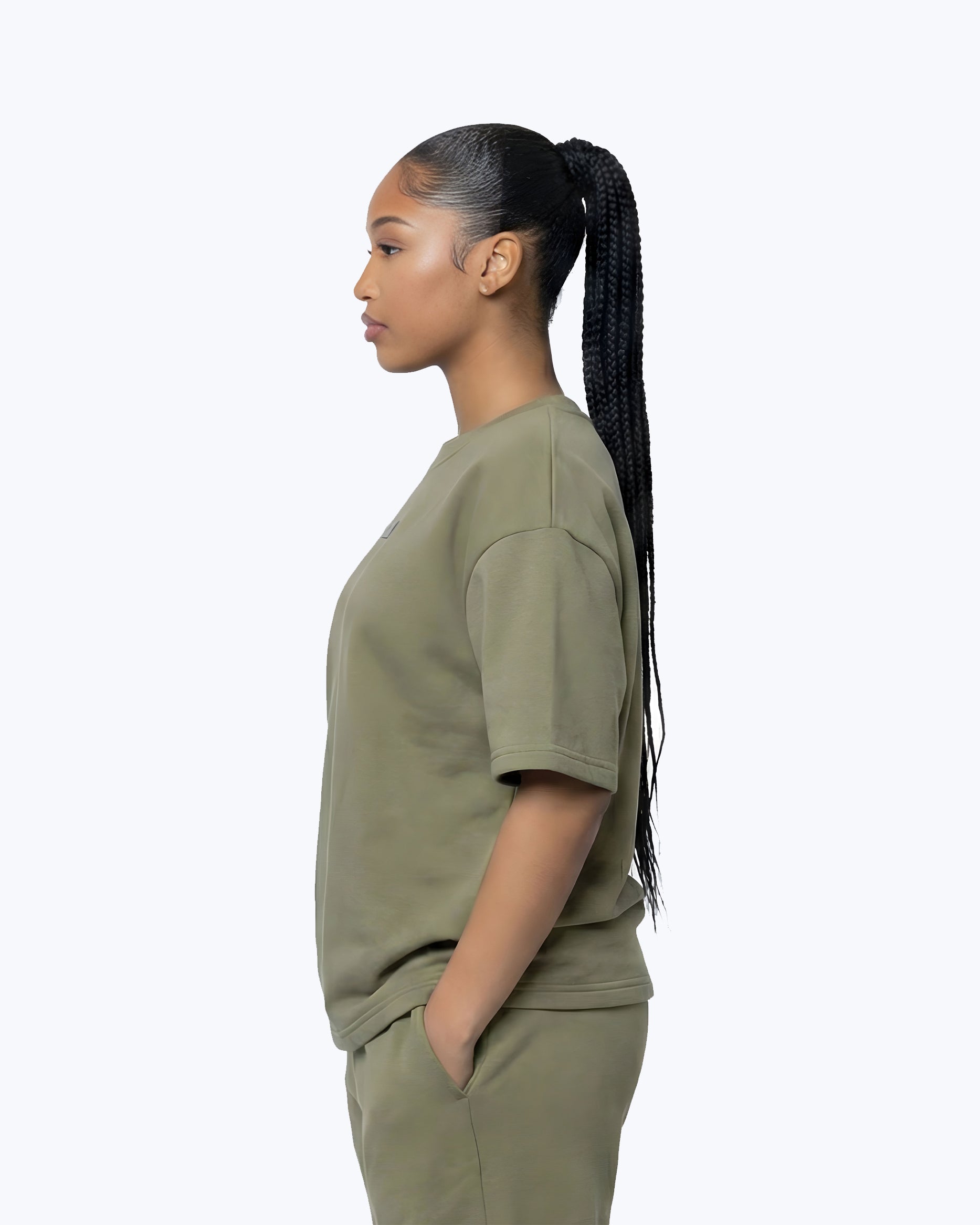 Woman in olive green Dope Beyond premium streetwear t-shirt and shorts, side profile