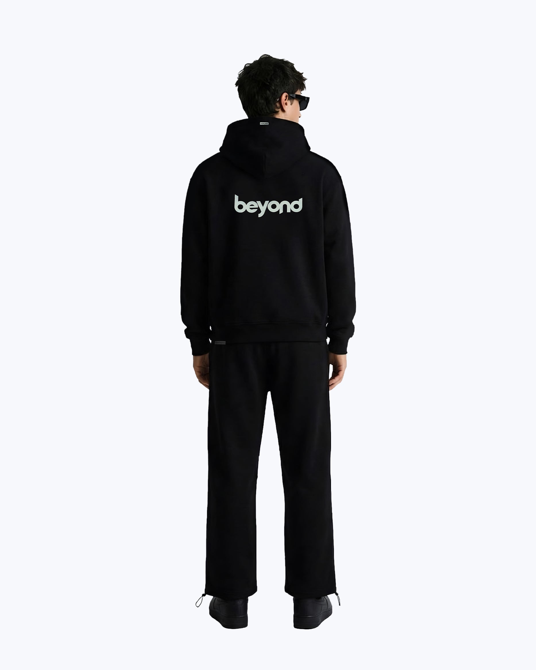 Male model wearing black Dope Beyond heavyweight streetwear cord set, back view, logo visible.