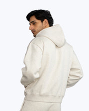 Man wearing light beige streetwear hoodie by dopebeyond, turned slightly away