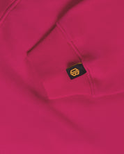 Close-up of a bright pink streetwear hoodie sleeve with Dope Beyond logo tag