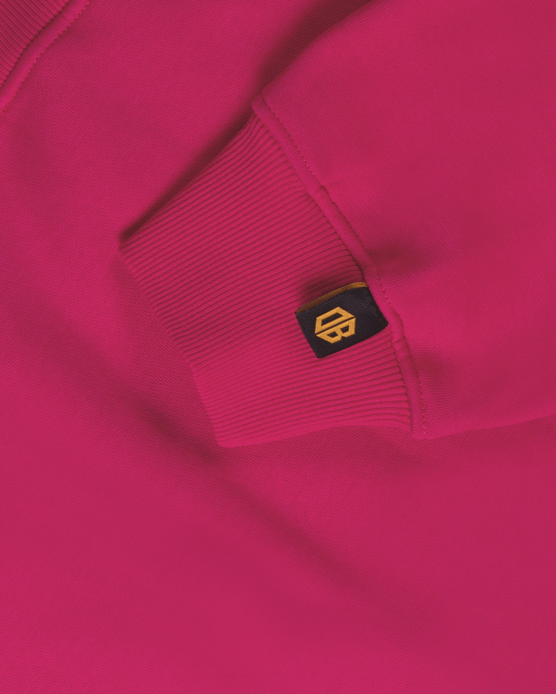 Close-up of a bright pink streetwear hoodie sleeve with Dope Beyond logo tag