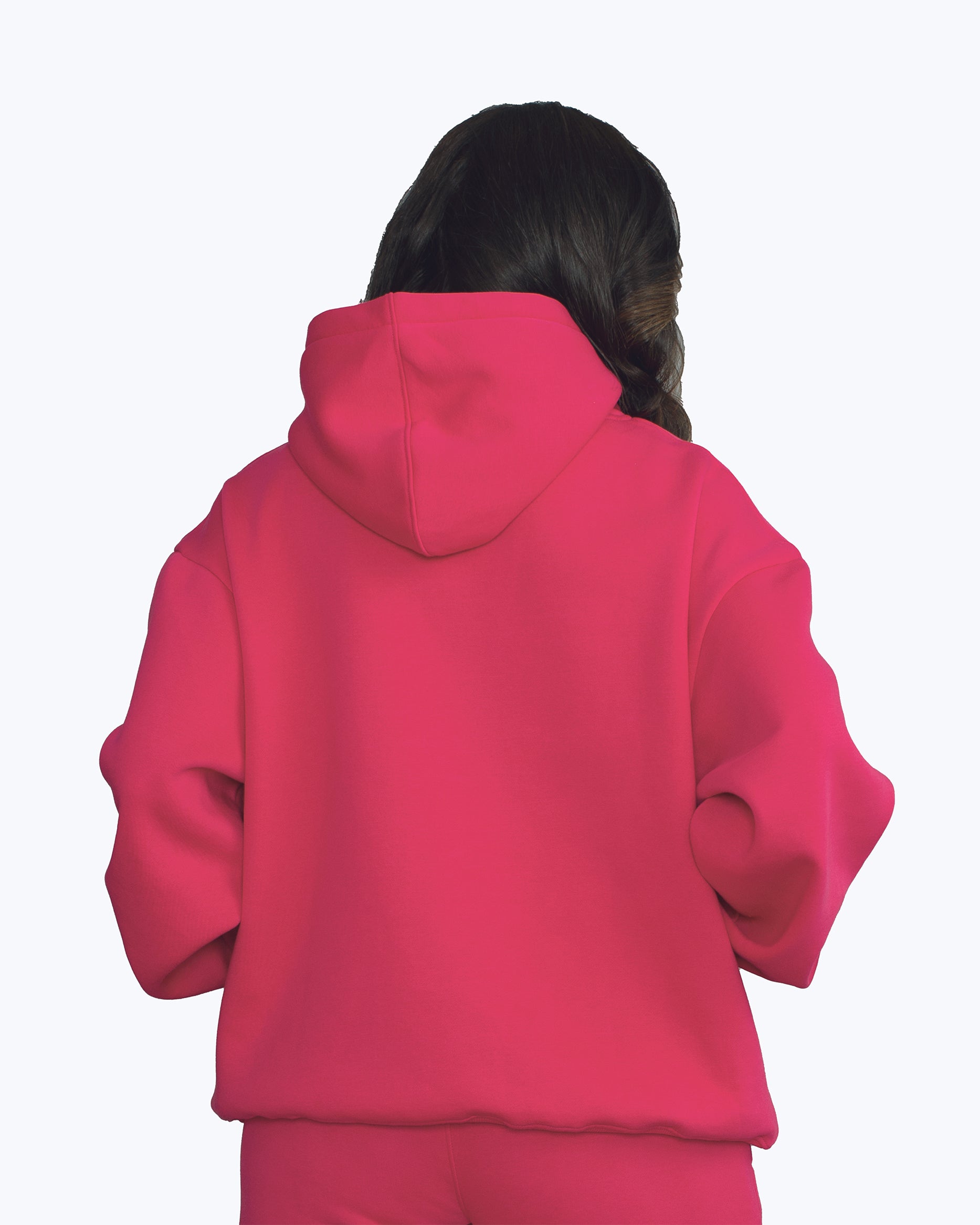 Back view of a woman wearing a vibrant pink streetwear hoodie from dopebeyond