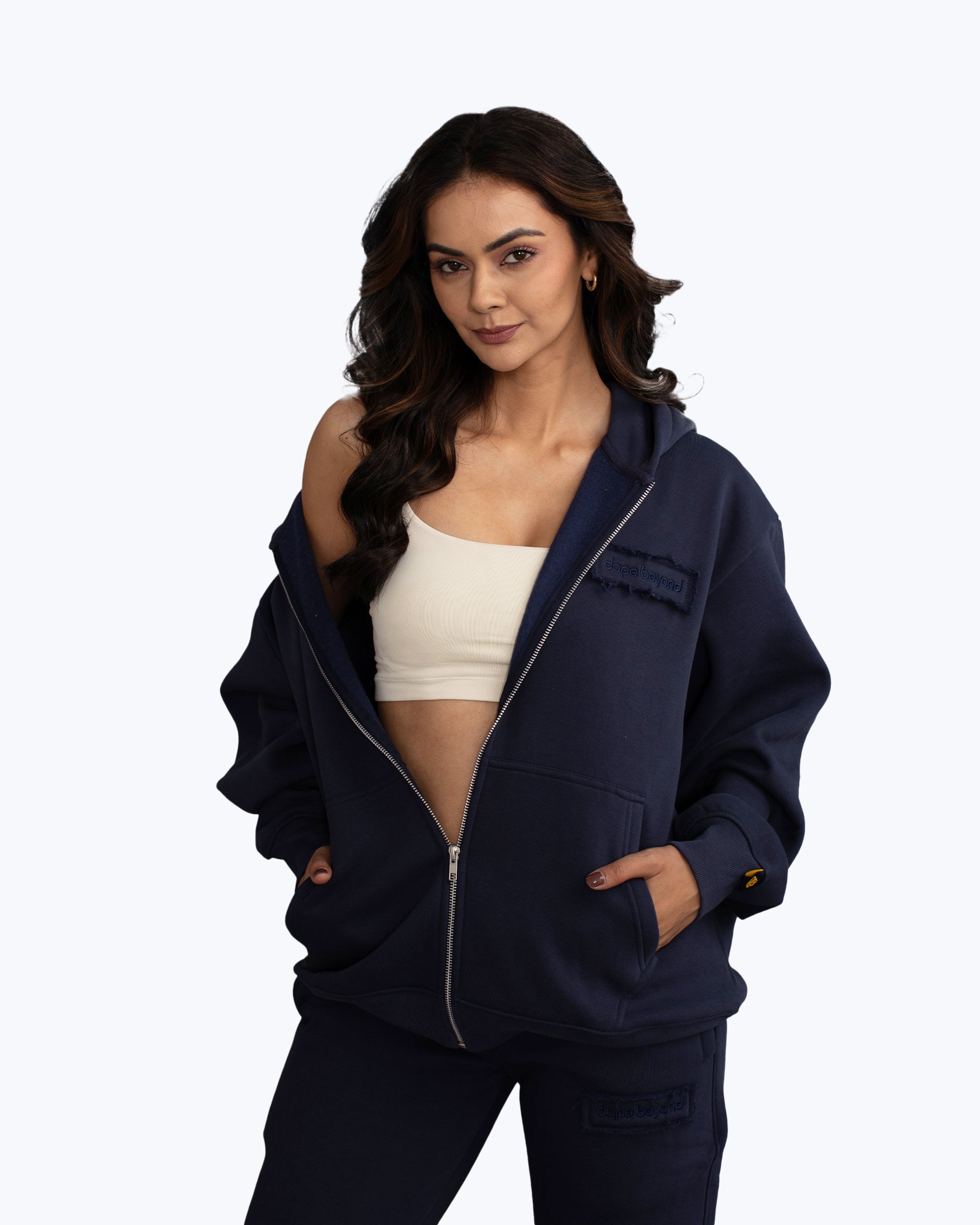 Woman modeling navy dopebeyond streetwear hoodie and joggers with cream crop top