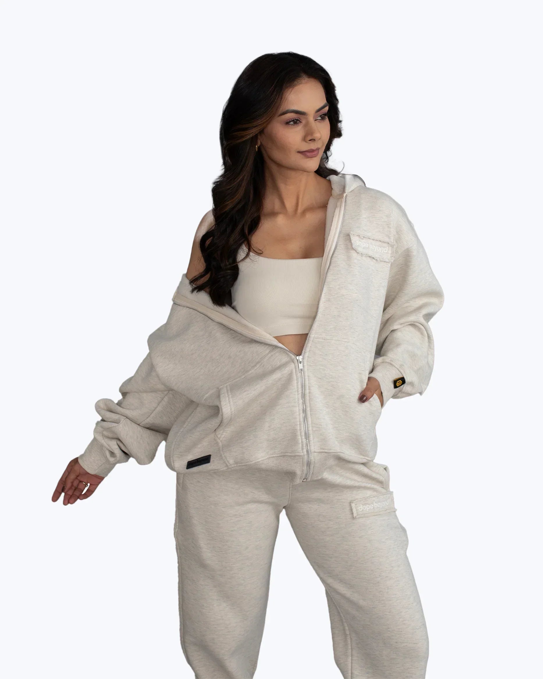Woman modeling dopebeyond beige streetwear hoodie and sweatpants set on white background