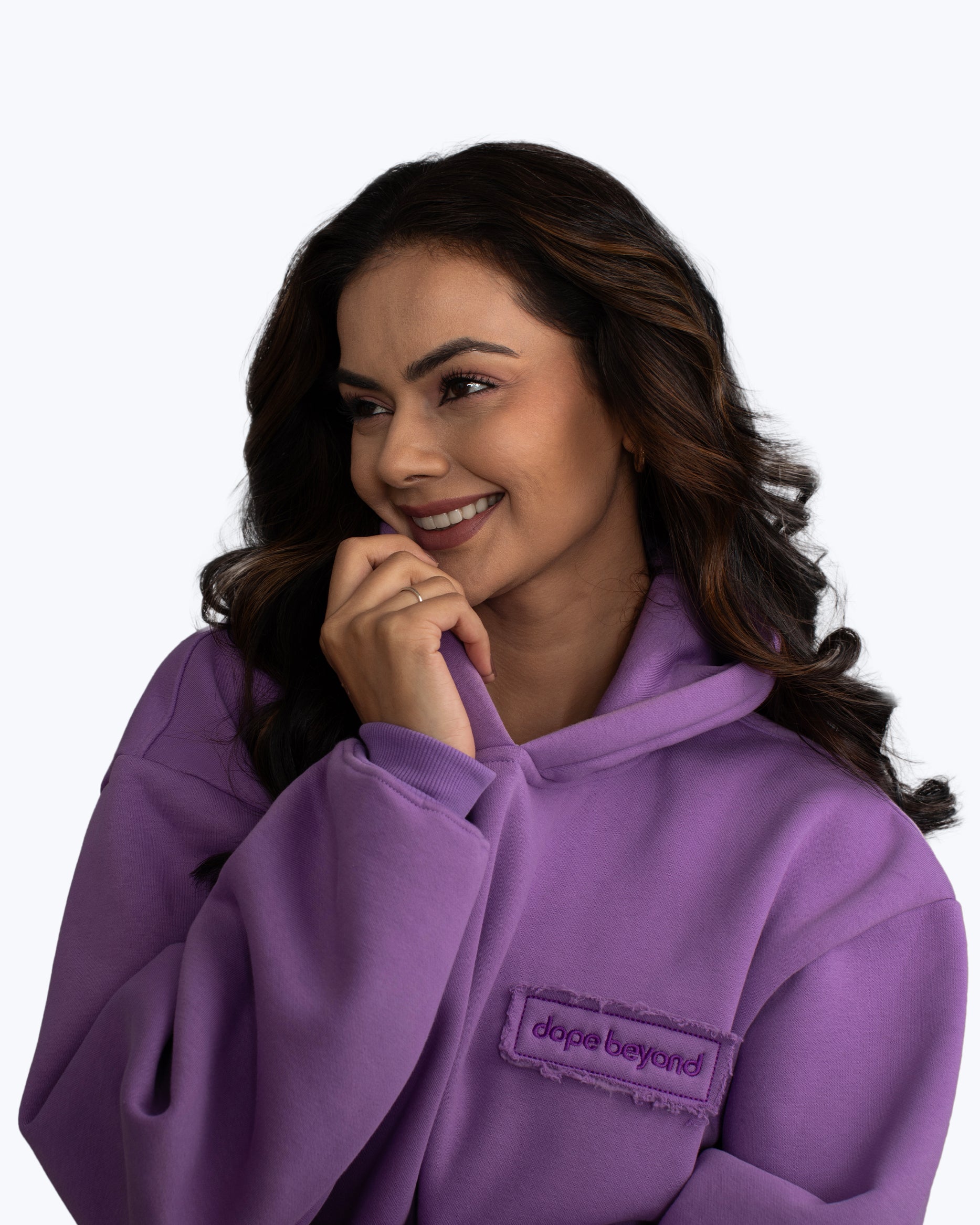 Woman smiling in a purple dope beyond hoodie, streetwear fashion apparel.