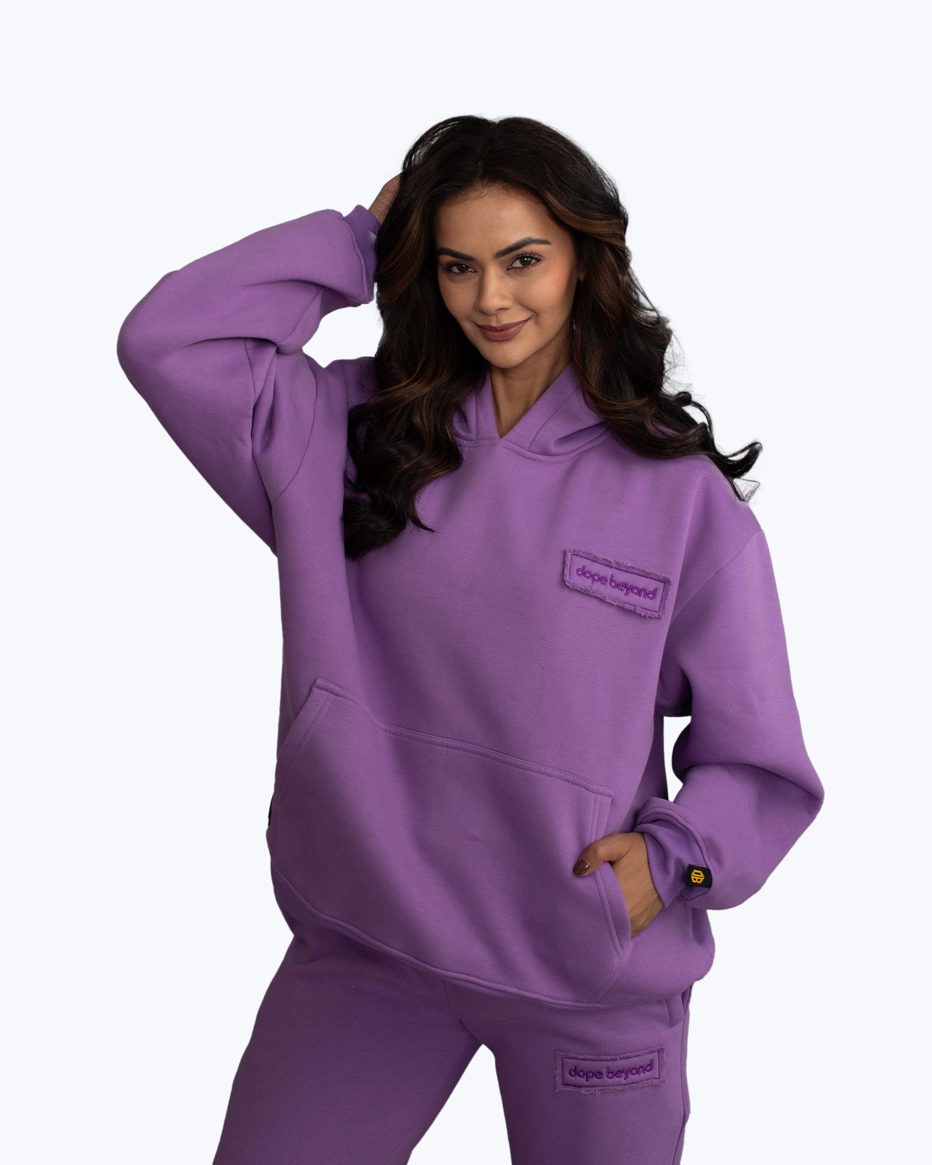 Woman in purple dopebeyond hoodie and joggers, streetwear fashion, white background