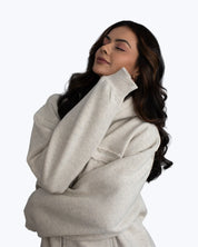 Woman wearing a light grey dopebeyond hoodie, relaxed pose, streetwear fashion