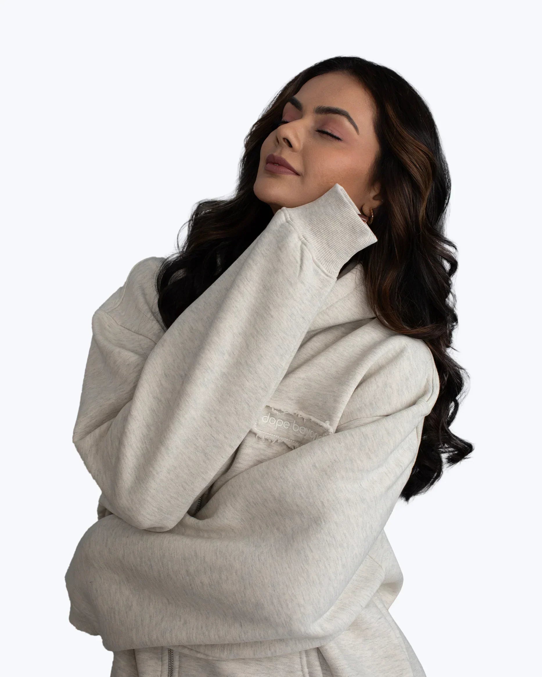 Woman wearing a light grey dopebeyond hoodie, relaxed pose, streetwear fashion