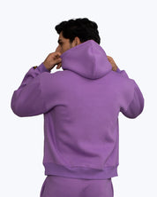 Man in purple hoodie and matching pants adjusting hood, streetwear by dopebeyond