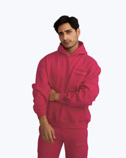Man wearing dopebeyond bright pink streetwear hoodie and sweatpants, minimal background
