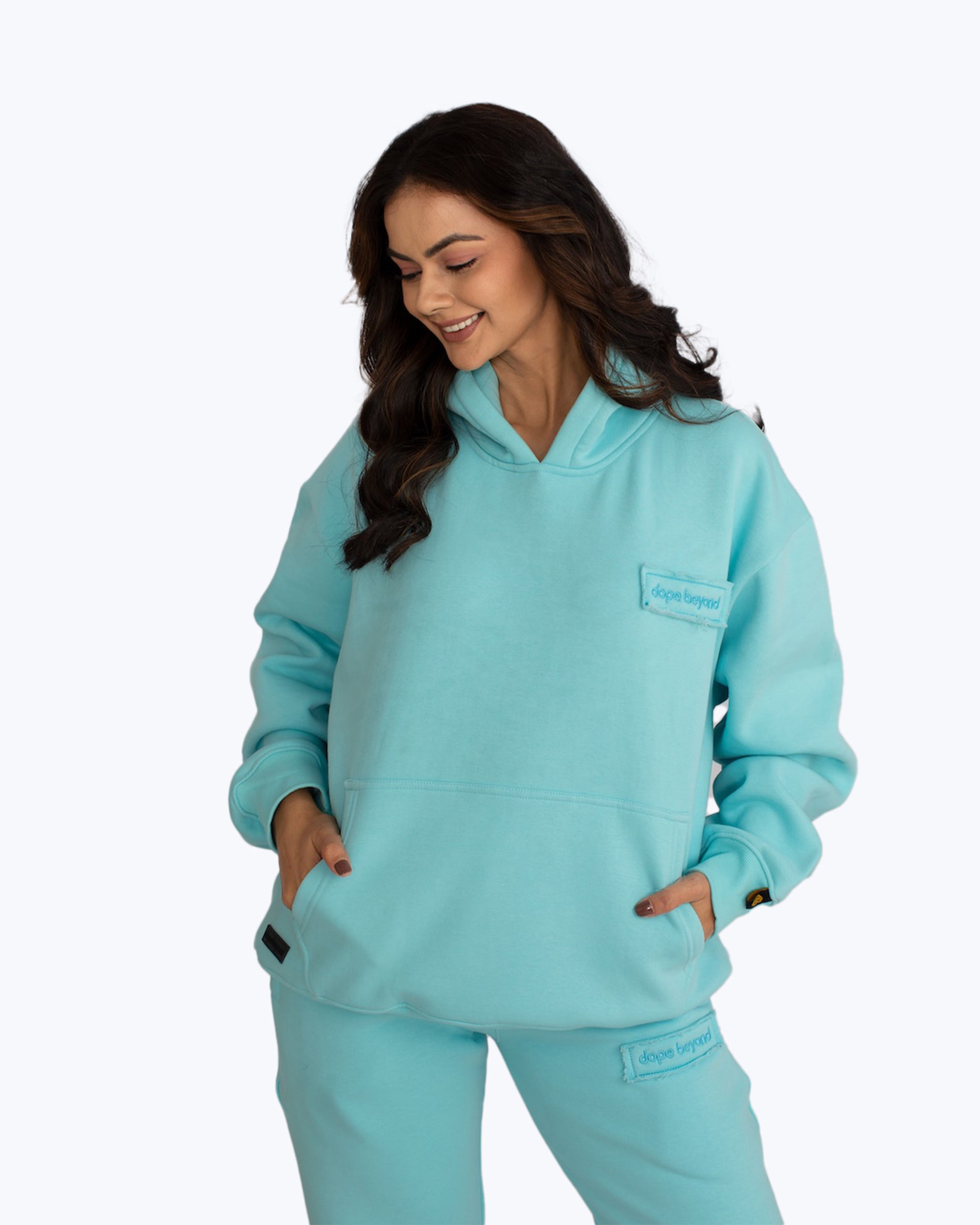Woman wearing light blue dopebeyond hoodie and sweatpants streetwear set