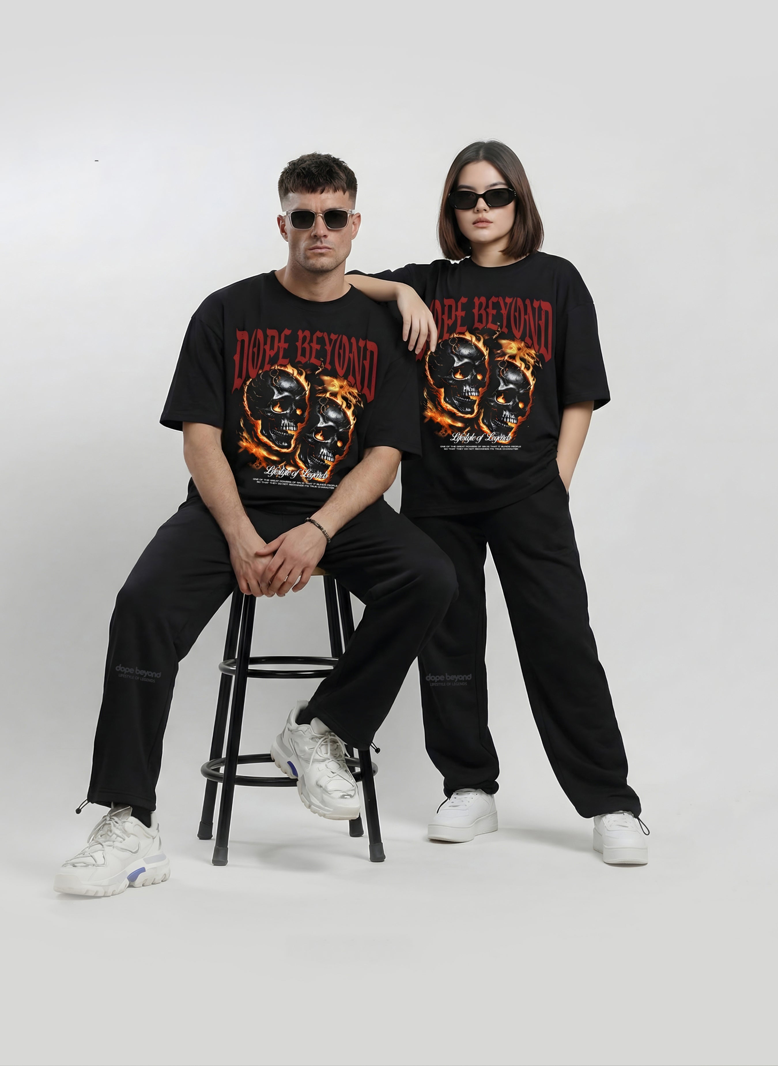 Two models wearing black Dope Beyond skull graphic t-shirts with black pants
