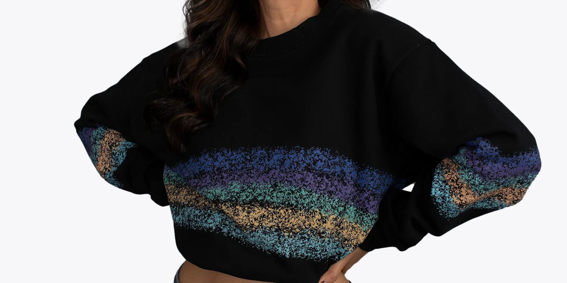 Woman modeling black cropped hoodie with colorful textured stripes, dopebeyond streetwear style