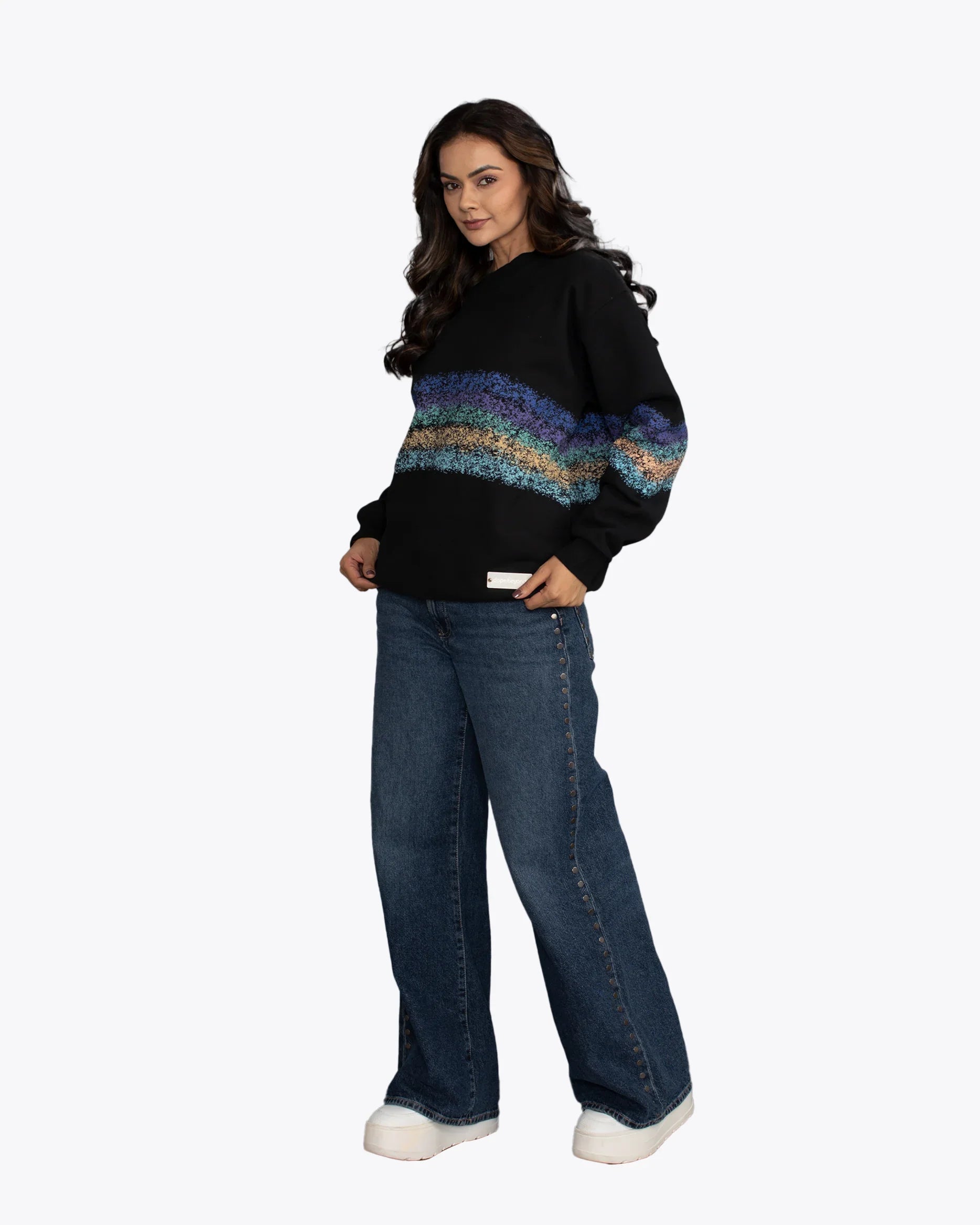 Woman modeling dopebeyond black streetwear hoodie with colorful stripe, wide-leg jeans