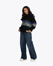 Woman wearing a black streetwear hoodie with colorful stripes and wide-leg jeans, dopebeyond