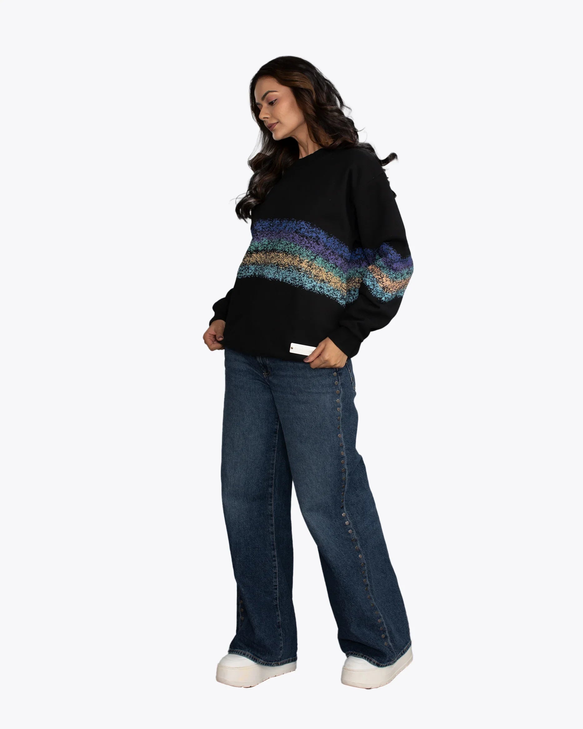 Woman in dopebeyond black streetwear hoodie with colorful horizontal stripes and wide-leg jeans