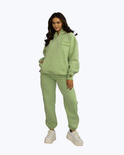 Woman modeling green dopebeyond streetwear hoodie and joggers set, white platform sneakers