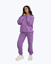 Woman wearing lavender purple dopebeyond streetwear hoodie and sweatpants set, white sneakers