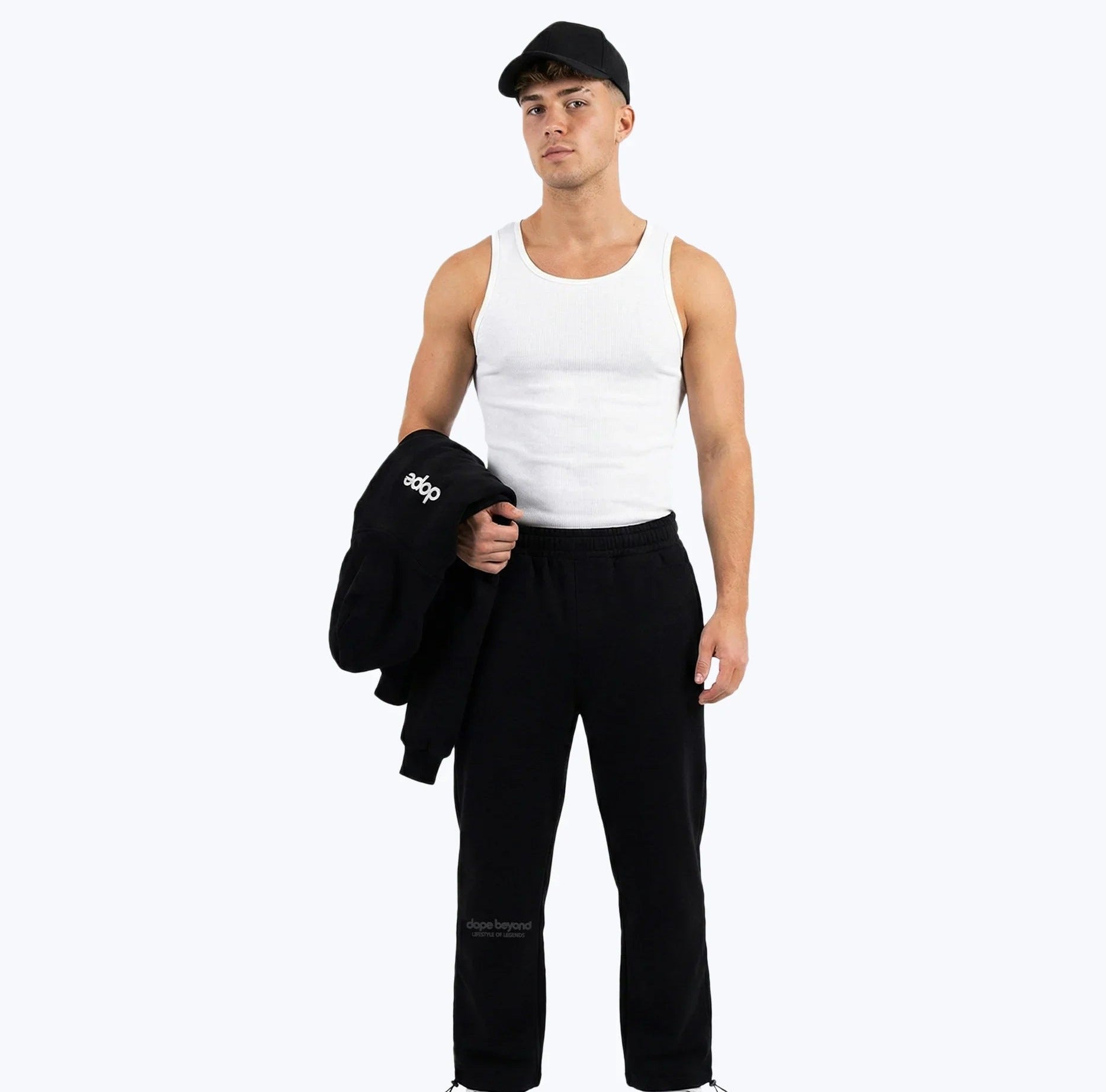 Jet black Legends heavyweight joggers by Dope Beyond – front view on male model holding the matching hoodie