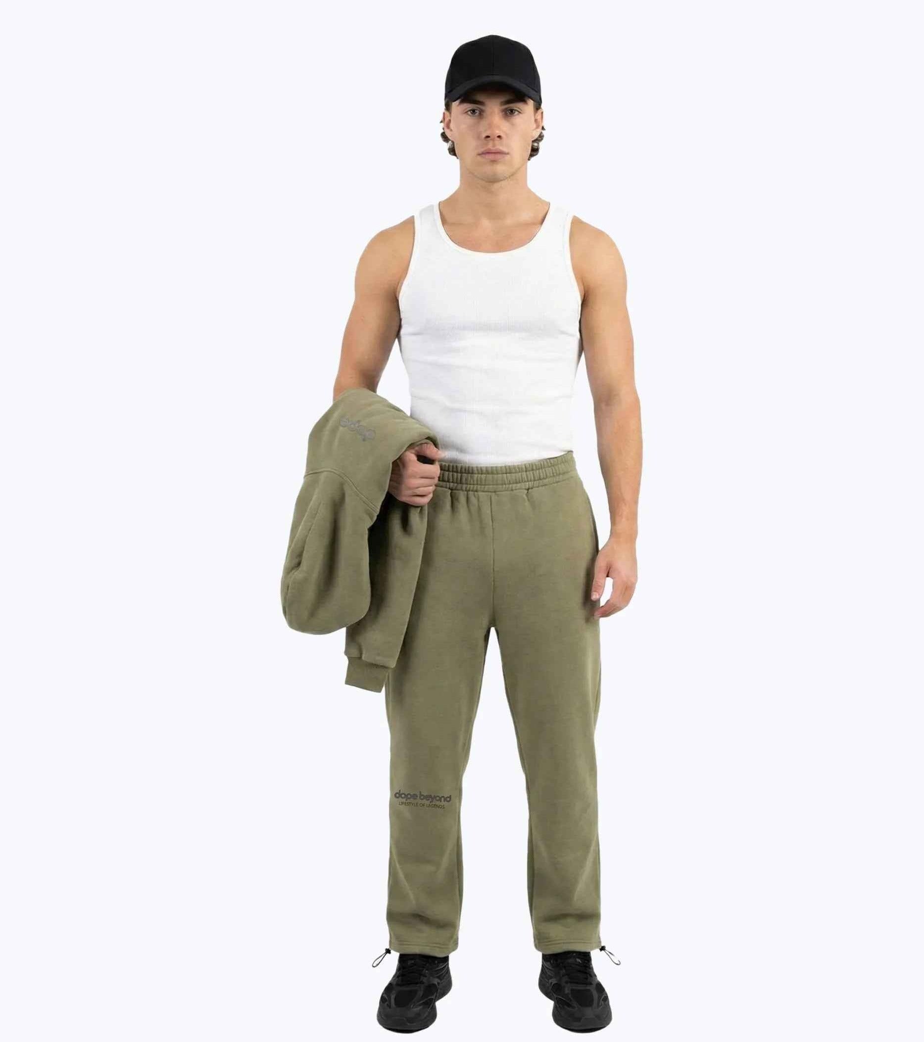 Olive green Legends heavyweight joggers by Dope Beyond – front view on male model holding the matching hoodie