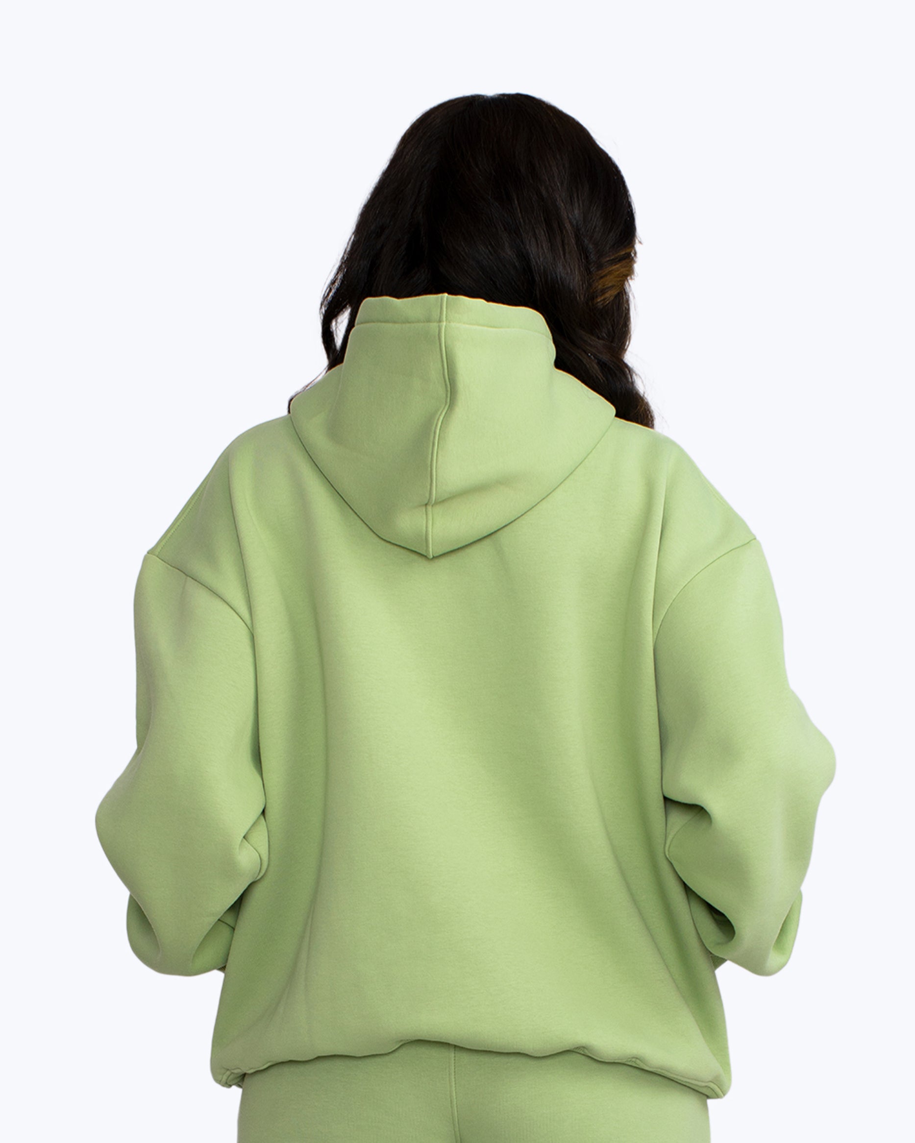 Back view of person in mint green streetwear hoodie and pants, dopebeyond style