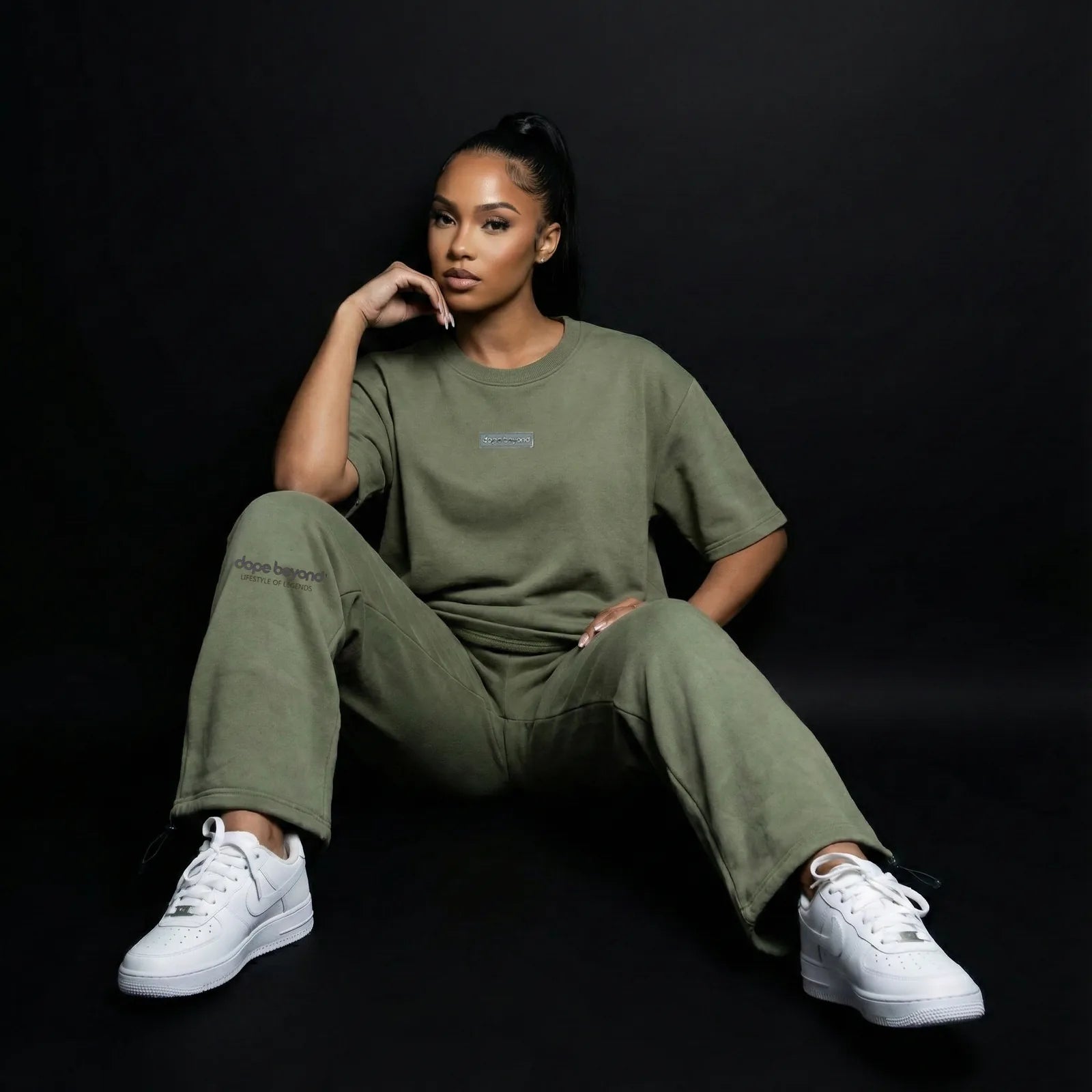 Model in olive green Dope Beyond t-shirt and matching sweatpants with white sneakers