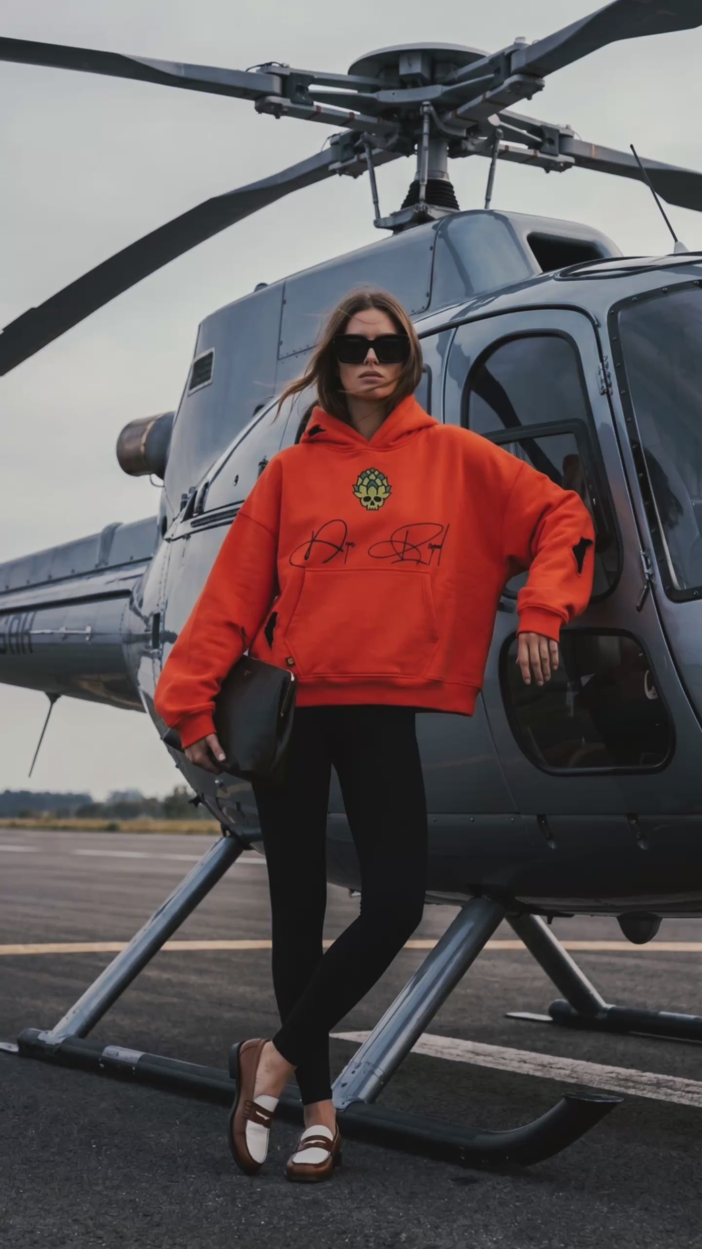 Orange Skull in Bloom heavyweight hoodie by Dope Beyond – video on female model by a helicopter